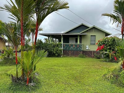 Exterior view of a green house surrounded by greenery