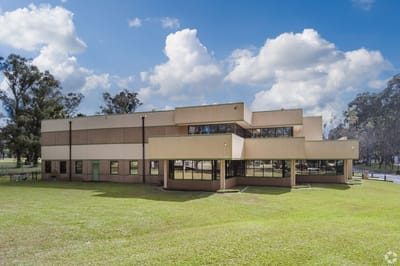 Exterior view of a modern assisted living facility surrounded by grass