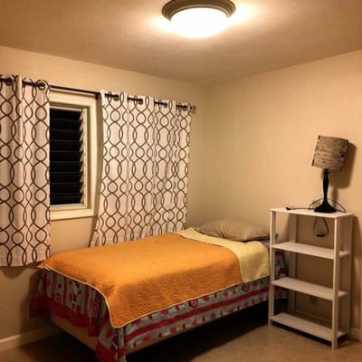 A simple private resident room with a bed and shelf