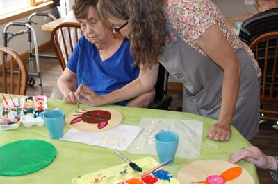 Resident and staff member engaged in an arts and crafts activity