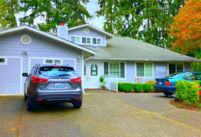 Exterior view of a senior care facility with vehicles