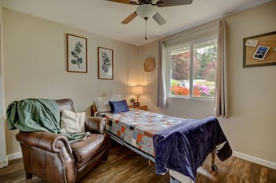 Cozy resident room with a bed and an armchair