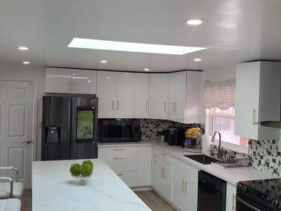Modern kitchen with white cabinets and a skylight