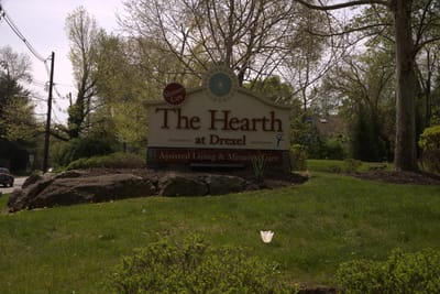 Sign for The Hearth at Drexel surrounded by greenery