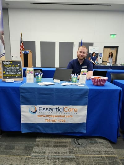 Staff member at a promotional table for Essential Care