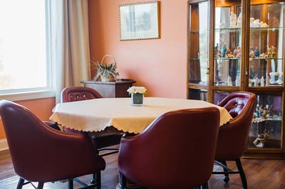 A bright common area with a dining table and display cabinet