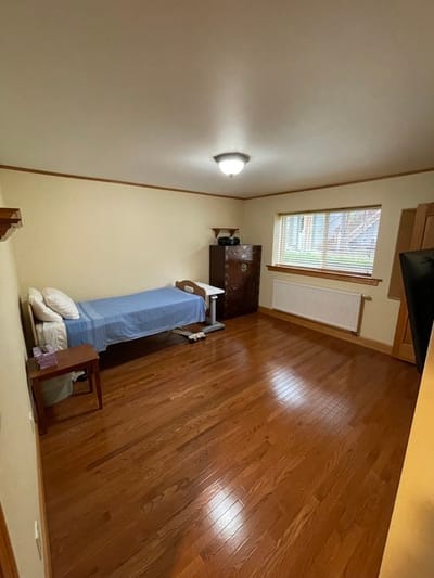 Cozy private room with wooden flooring and bed