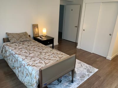 Cozy resident room with a bed and bedside table