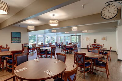 Dining room setup with wooden tables and blue chairs