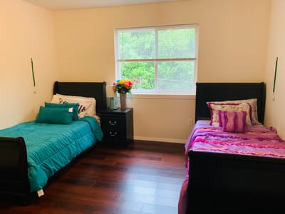 Cozy bedroom with two beds and a vase of flowers