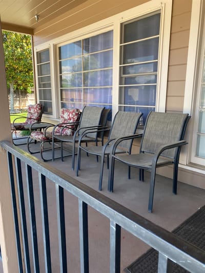 Chairs on a porch with flowers nearby