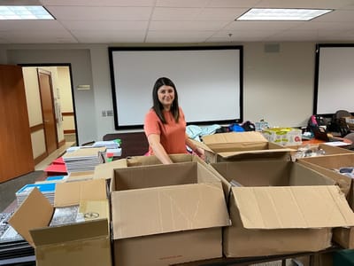 Staff member organizing supplies in a common area