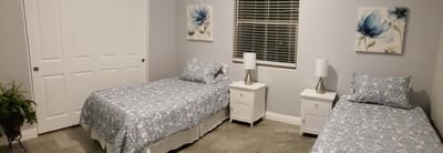 Bright resident room with two beds and decor