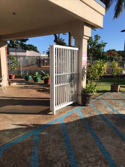 Exterior gated entry with potted plants