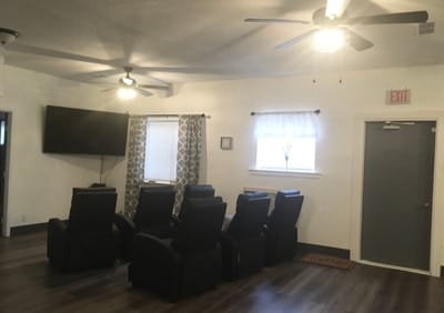 A cozy seating area with reclining chairs and a TV
