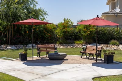 Outdoor seating area with red umbrellas and benches