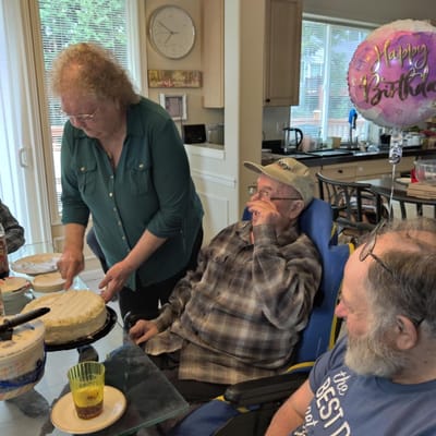 Residents celebrating a birthday with cake and balloons