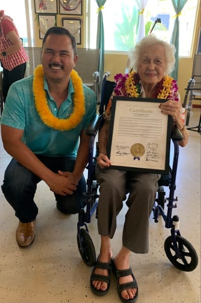 Resident receiving a certificate with staff member