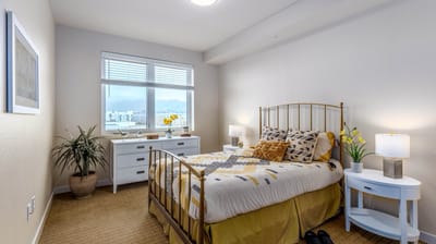 A well-decorated resident room with a bed and flowers