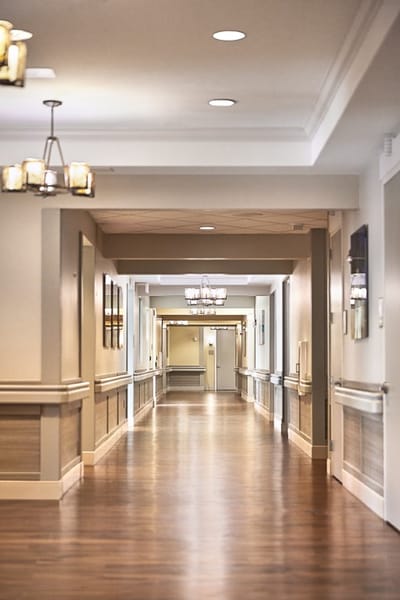 Bright hallway with overhead lighting in a senior facility