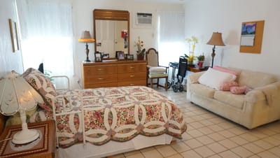 A cozy resident room with floral bedding and furniture