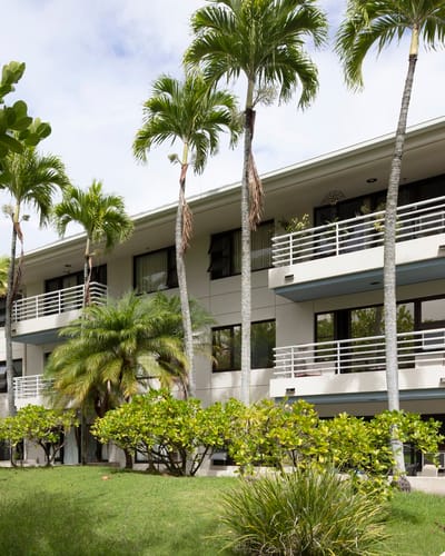 Exterior view of Lani Huli Elderly Apartments surrounded by palm trees