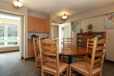 Bright common area with wooden dining table and chairs