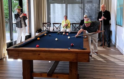 Residents enjoying a game of billiards in a common area