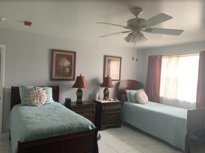Bright resident bedroom with two beds and lamps