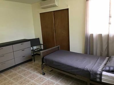 A private resident room with a bed and dresser