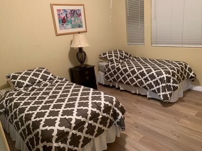 A shared resident room with two beds and a lamp