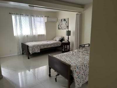 A shared resident room with two beds and windows