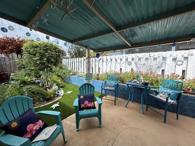 A serene outdoor seating area with colorful chairs and plants