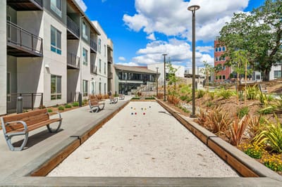 Outdoor bocce ball court with seating and gardens