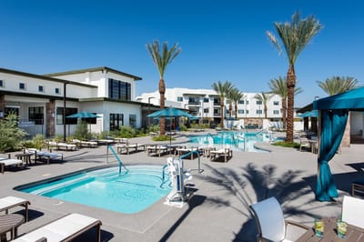 Outdoor pool area with lounge chairs and palm trees
