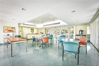 Common area with tables and chairs in a senior residence