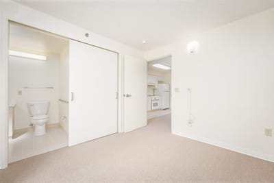 Empty resident room with bathroom and kitchenette