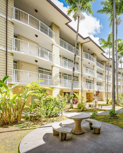 Exterior view of senior residence with garden and seating area