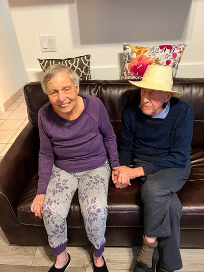 Elderly couple sitting together on a couch