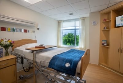 A private room with a hospital bed and window view