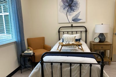 Bright and inviting resident room with a bed and chair