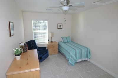 A private resident room with a bed and chair