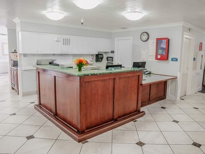 A bright reception area with a front desk and flowers