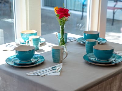 Colorful dining setup with blue dishes and flowers