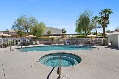 Outdoor pool and spa area with umbrellas
