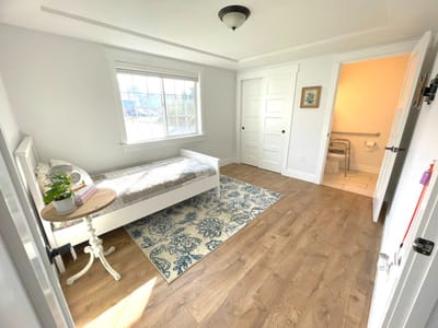 Bright, clean resident room with bed and decor