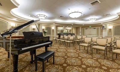 Interior view of a common area with piano and chairs