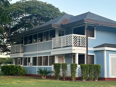 Exterior view of a two-story blue building with balconies