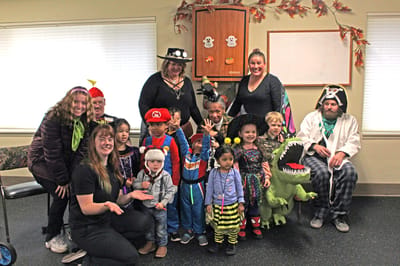 Residents and children in a festive activity room
