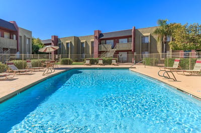 Outdoor pool with seating area and building view